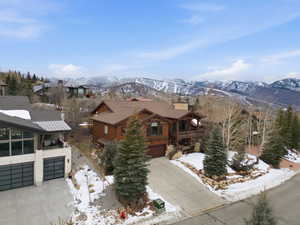 View of front facade featuring concrete driveway, an attached garage, a mountain view, and a balcony