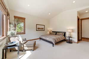 Bedroom featuring light colored carpet, vaulted ceiling, and recessed lighting