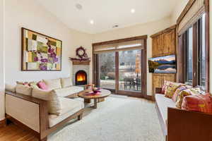 Living area with a lit fireplace, recessed lighting, and light wood finished floors
