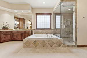 Bathroom with a stall shower, vanity, light tile patterned floors, a garden tub, and recessed lighting