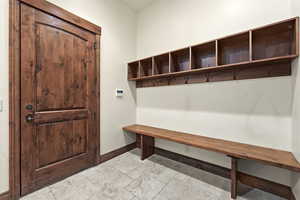 Mudroom featuring stone tile flooring and baseboards