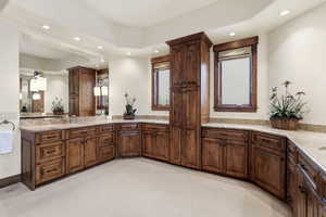 Full bathroom with vanity, a tray ceiling, light carpet, and recessed lighting