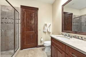 Bathroom featuring a stall shower, vanity, and light tile patterned floors