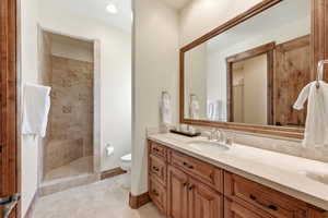 Bathroom with a walk in shower, vanity, light tile patterned flooring, and recessed lighting