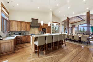 Kitchen with a breakfast bar area, plenty of natural light, a center island, a high ceiling, and wood finish cabinetry