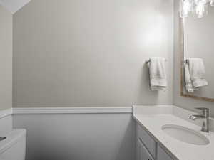 Half bathroom featuring vanity and toilet