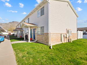 View of property exterior with brick siding and a mountain view