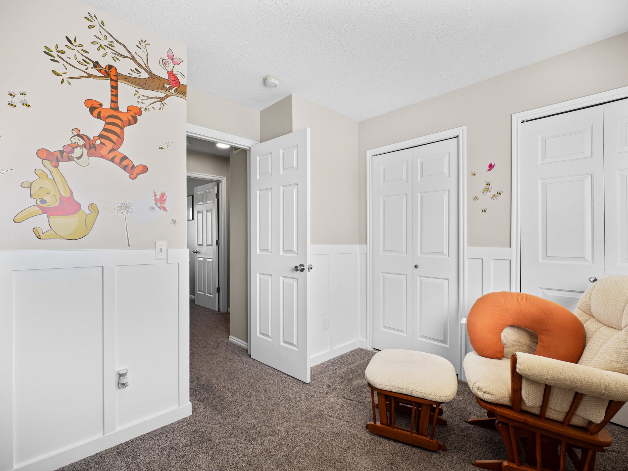 Sitting room featuring a wainscoted wall, a decorative wall, and dark carpet