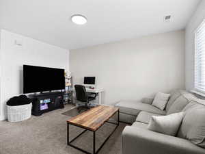 Carpeted living area with a desk