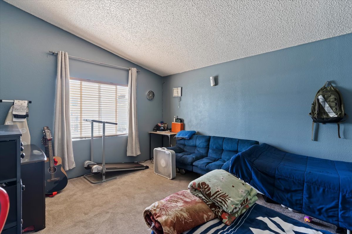 Bedroom with carpet and a textured wall