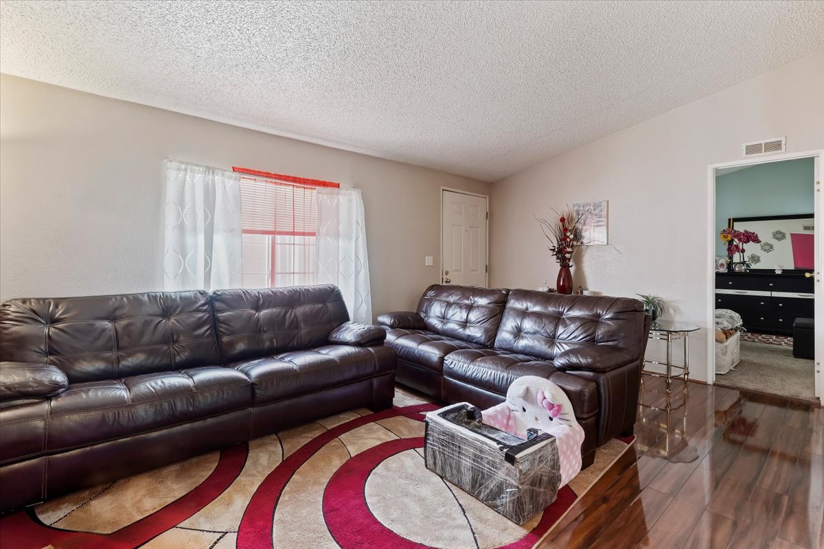 Living area with wood finished floors and a textured ceiling
