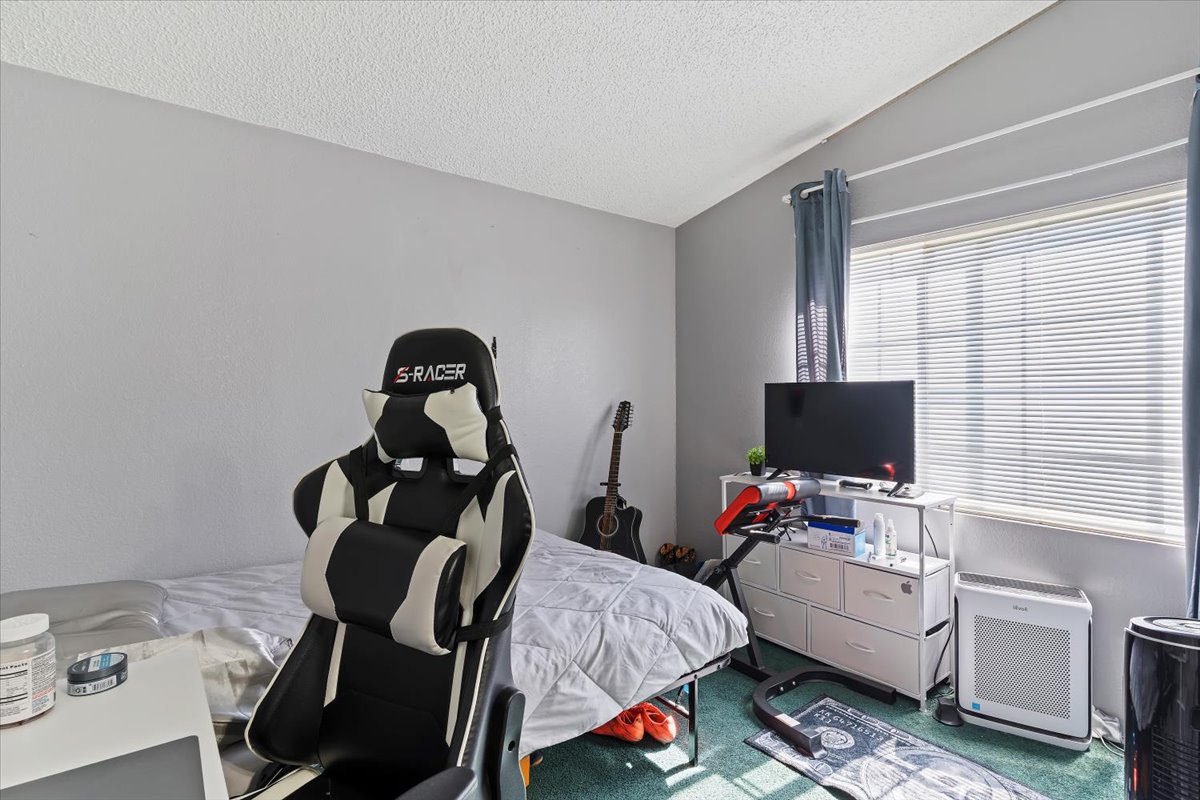 Bedroom featuring heating unit and carpet