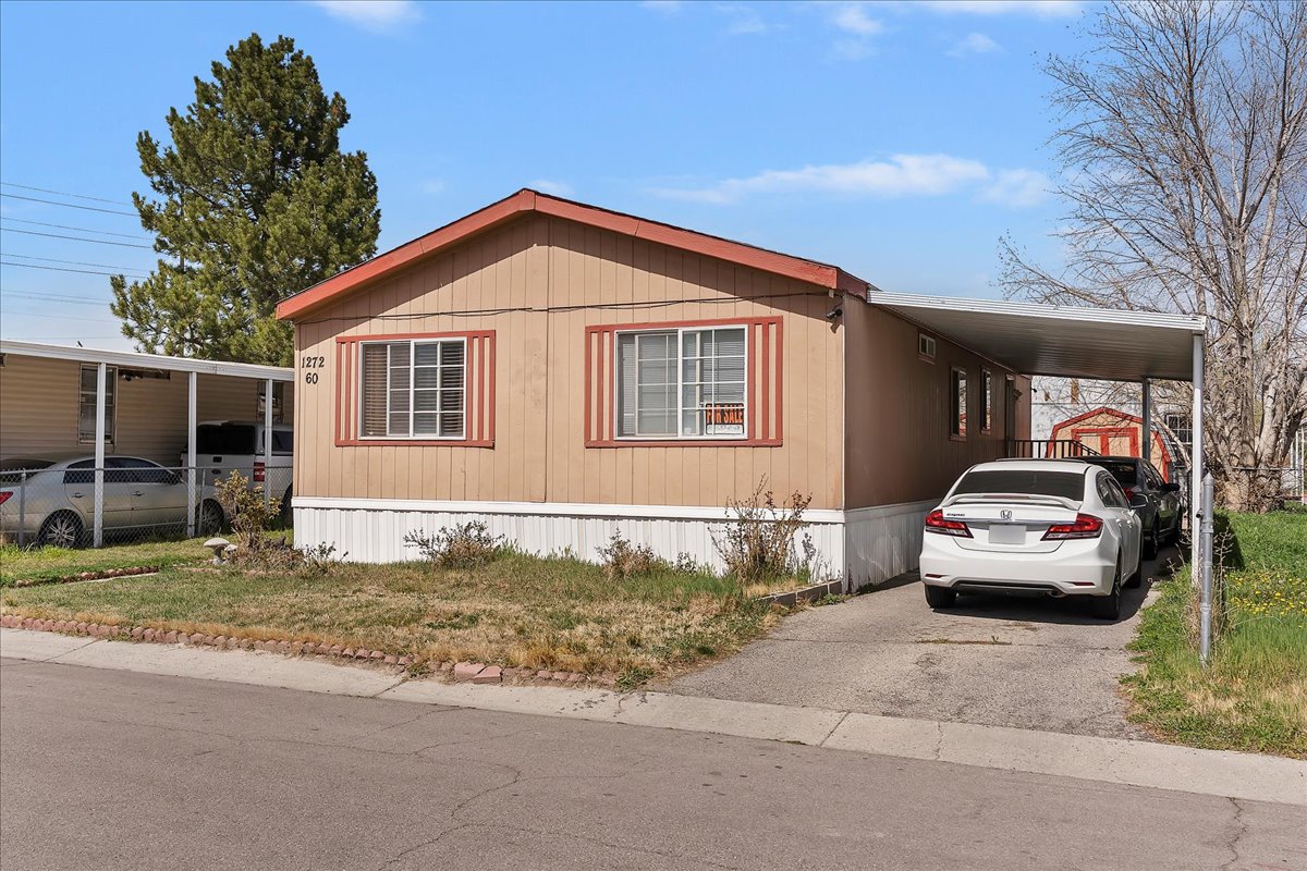 View of front facade featuring an attached carport and driveway