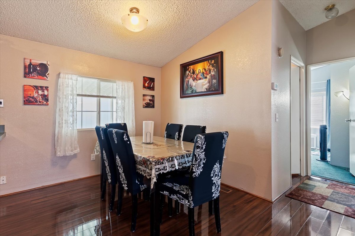 Dining area featuring a textured wall and wood finished floors