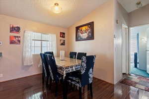 Dining area featuring a textured wall and wood finished floors