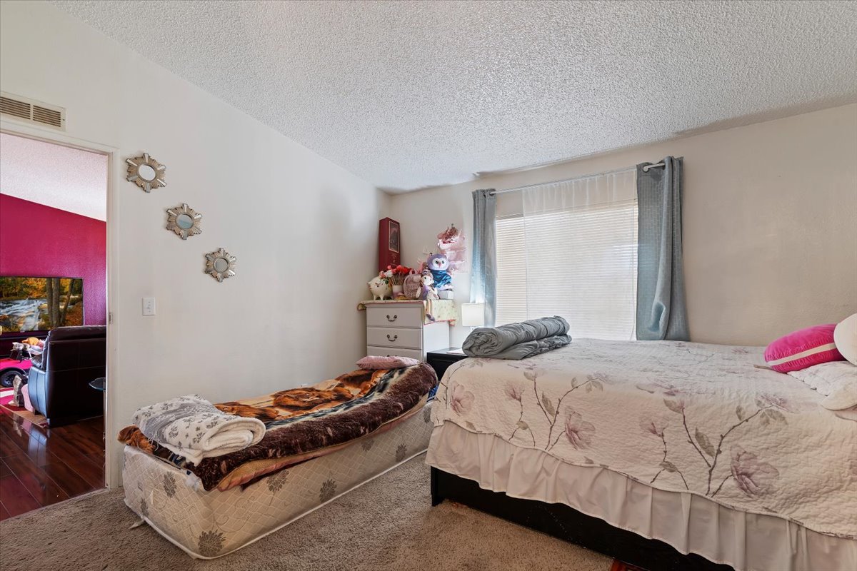 Carpeted bedroom featuring a textured ceiling