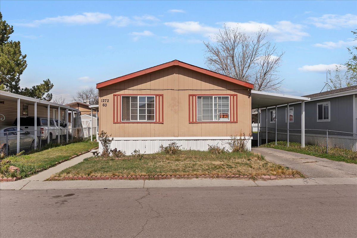 View of side of property featuring a carport and concrete driveway