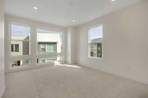 Carpeted spare room with baseboards and recessed lighting