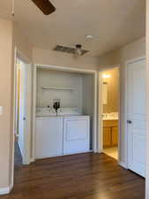 Laundry area with dark wood-style flooring, a ceiling fan, and washing machine and dryer