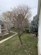 View of green lawn featuring a balcony