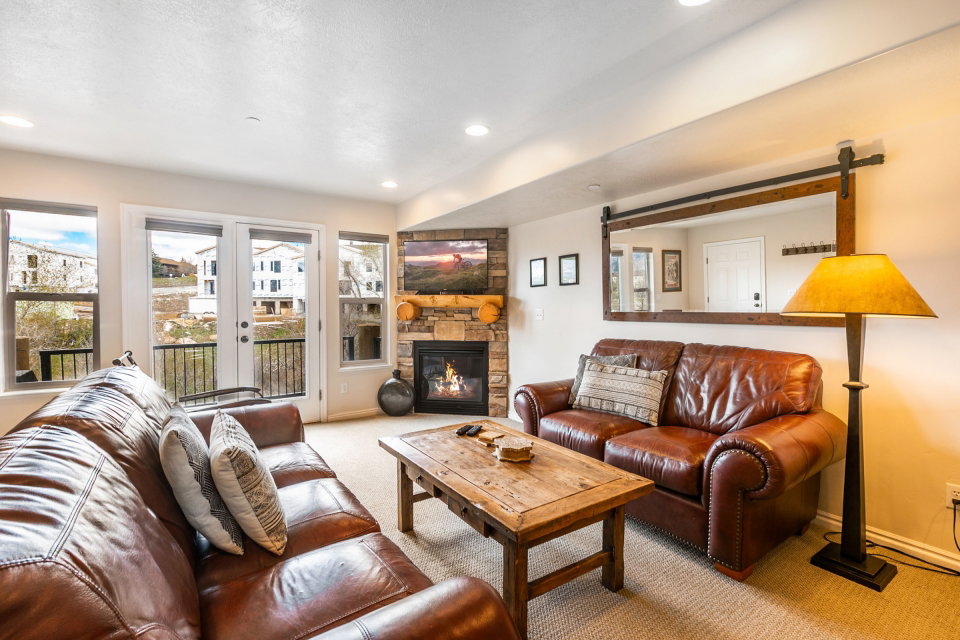 Living area with light carpet, a stone fireplace, a barn door, and recessed lighting