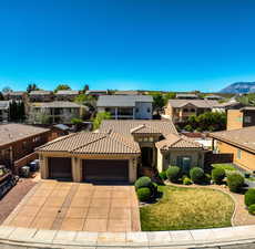 Mediterranean / spanish-style house featuring a garage, a residential view, driveway, and stucco siding