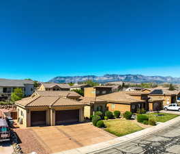 Mediterranean / spanish house featuring a residential view, a garage, stucco siding, and driveway