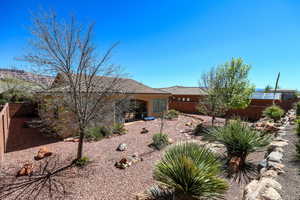 Back of property featuring a fenced backyard, stucco siding, a tiled roof, and a patio