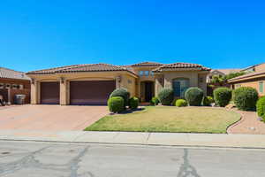 Mediterranean / spanish-style home featuring stucco siding, a garage, a front yard, driveway, and a tile roof