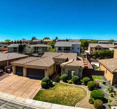 Mediterranean / spanish-style home featuring an attached garage, a residential view, concrete driveway, stucco siding, and a tile roof
