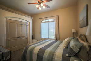 Bedroom with a closet, carpet, ceiling fan, and a textured ceiling