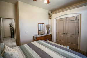 Bedroom featuring a closet, a ceiling fan, and a textured ceiling
