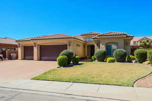Mediterranean / spanish-style home featuring stucco siding, a garage, a front lawn, concrete driveway, and a tile roof