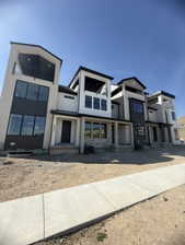 Contemporary townhome-style residences featuring multi-level facades, dark-framed windows, and integrated balconies