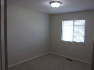 Unfurnished room featuring baseboards and carpet flooring