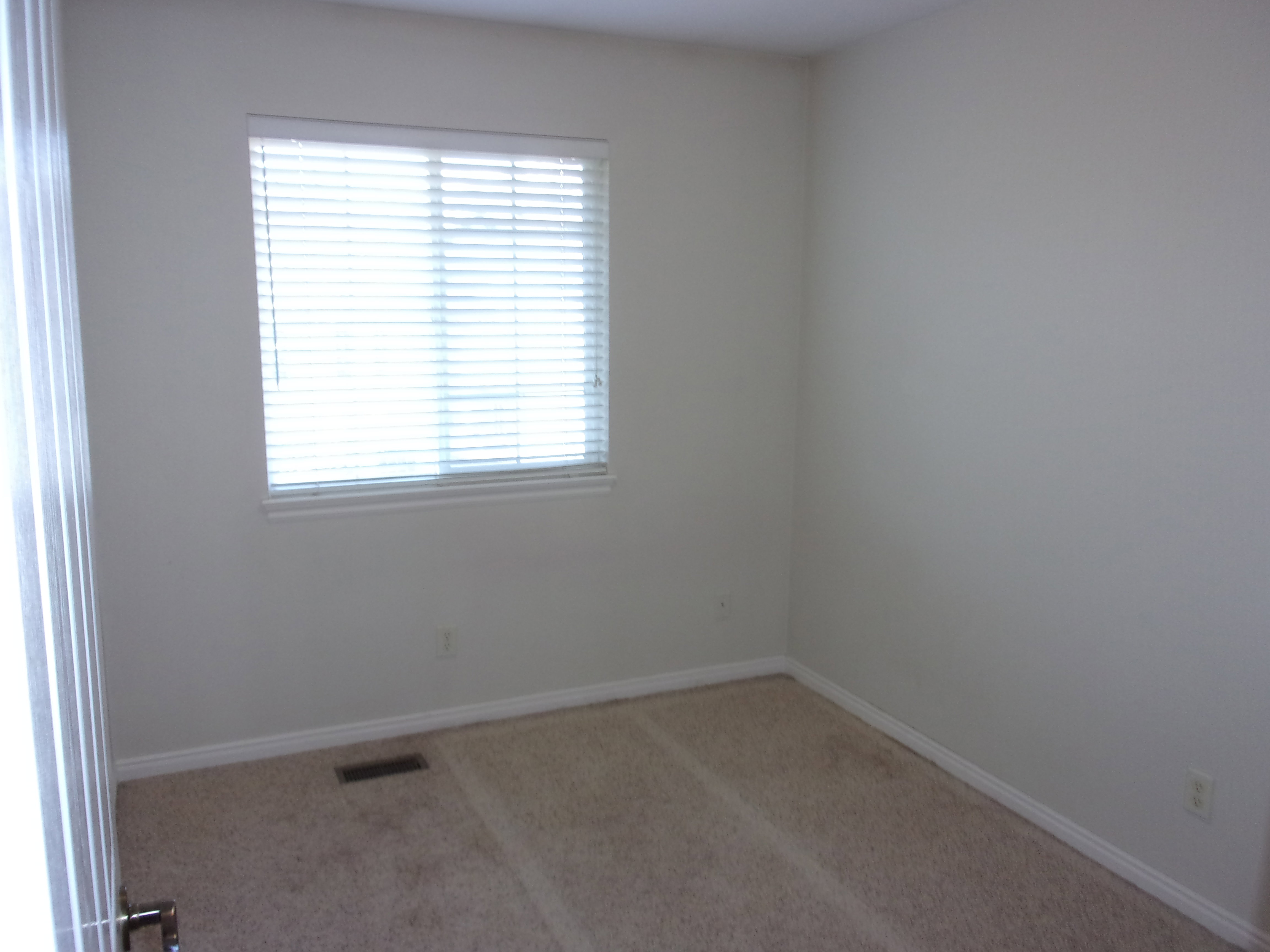 Spare room with light carpet and baseboards