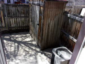 Fenced backyard featuring a storage shed