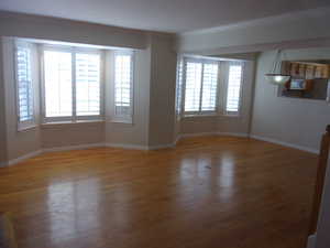 Unfurnished living room with light wood-style floors and ornamental molding