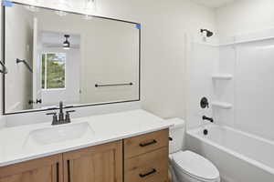 Bathroom with vanity, washtub / shower combination, and ceiling fan