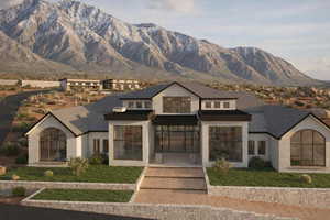 View of front of house featuring a mountain view, stucco siding, and a front lawn