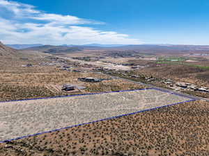 Aerial view of sparsely populated area featuring property parcel outlined and a mountainous background
