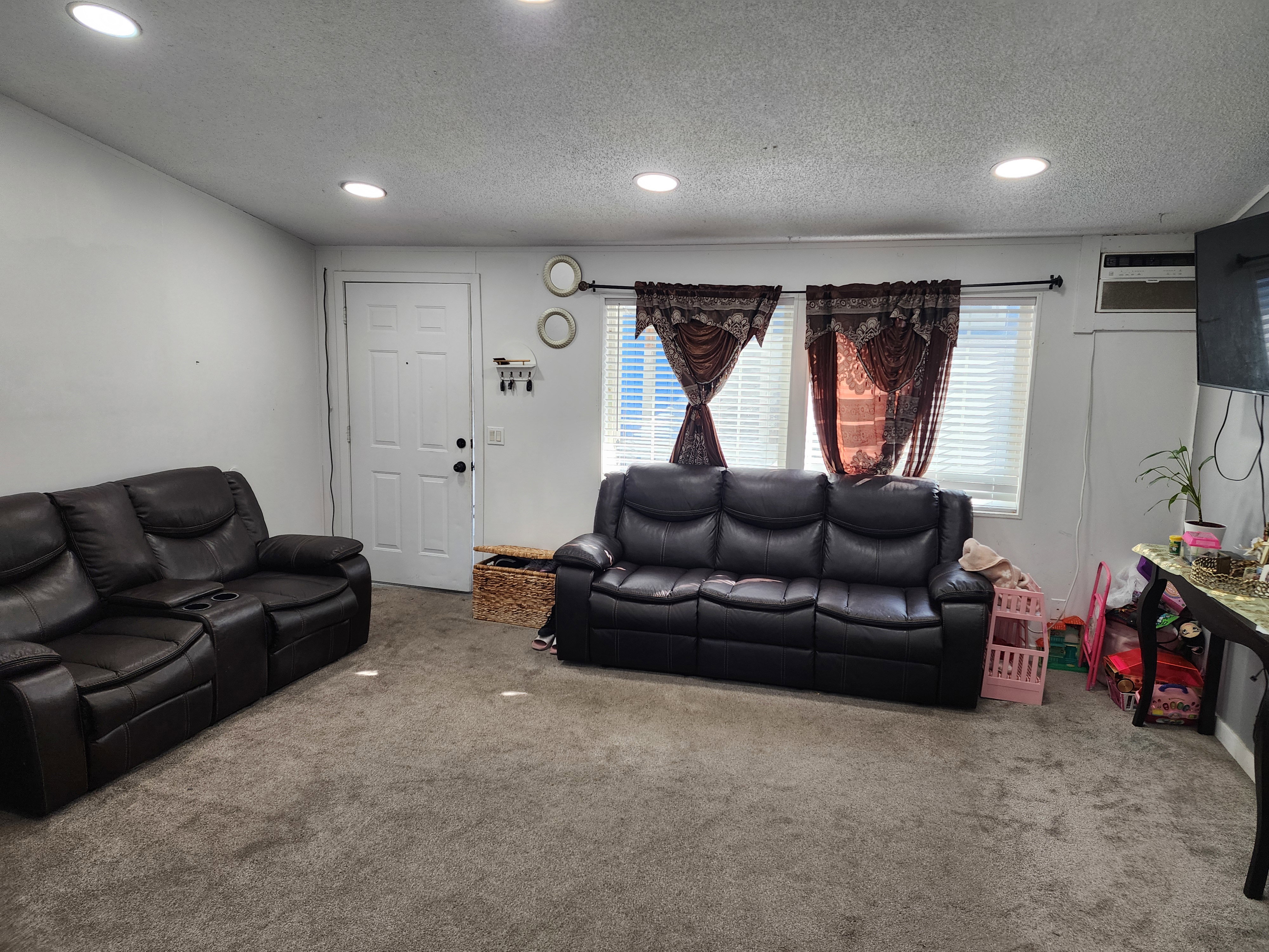 Carpeted living room with a textured ceiling and recessed lighting