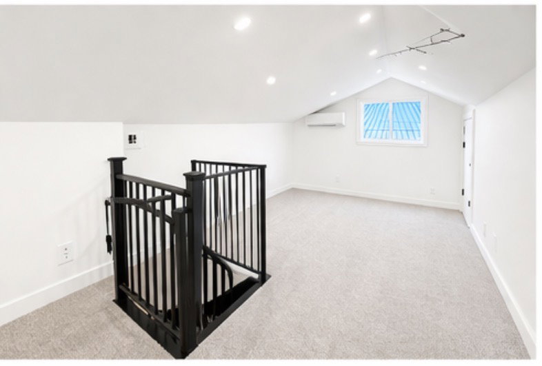 Additional living space with light colored carpet and recessed lighting