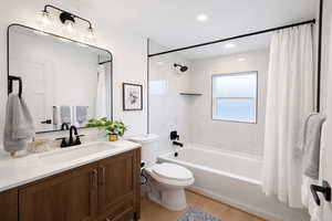 Full bath featuring vanity, shower / bath combo, and light wood finished floors