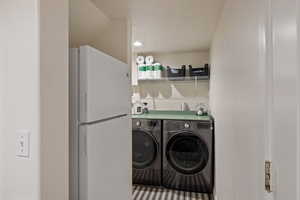 Laundry area featuring independent washer and dryer and recessed lighting