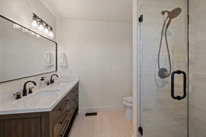 Full bath featuring double vanity and a stall shower