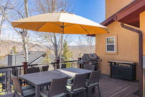 Wooden deck with outdoor dining space and area for grilling