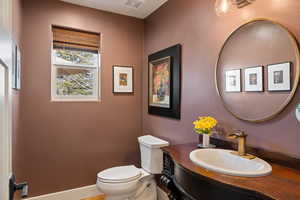 Half bathroom with toilet and vanity