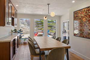 Dining space with light wood finished floors and recessed lighting