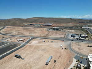 Aerial view of property and surrounding area featuring mountains and a desert landscape